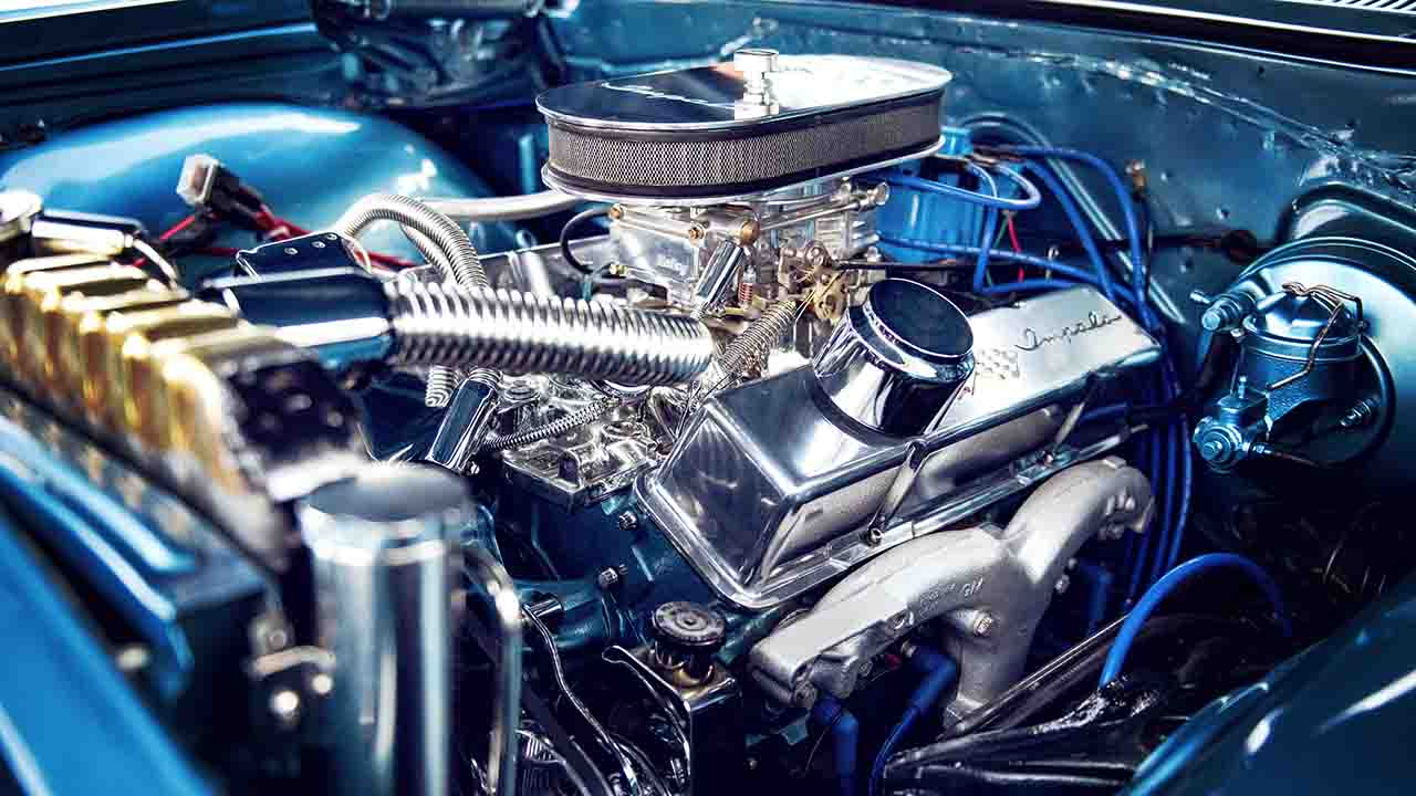 A close up shot of a car engine being tuned, showcasing various equipments used in the process.